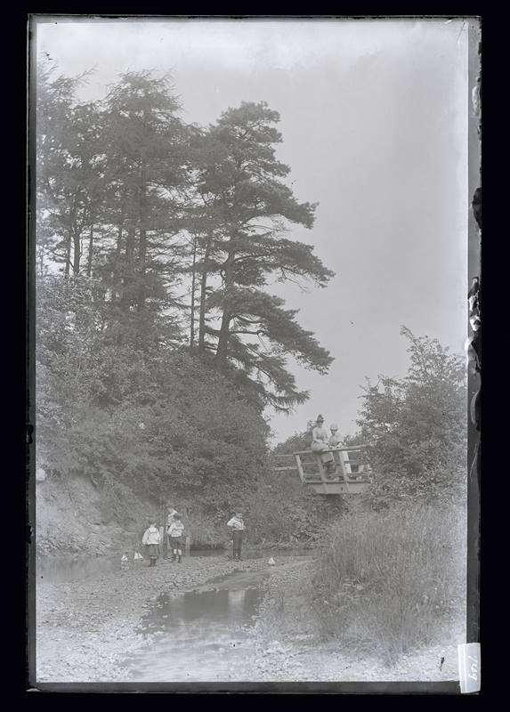 Children playing with model boats on a river, c.1900